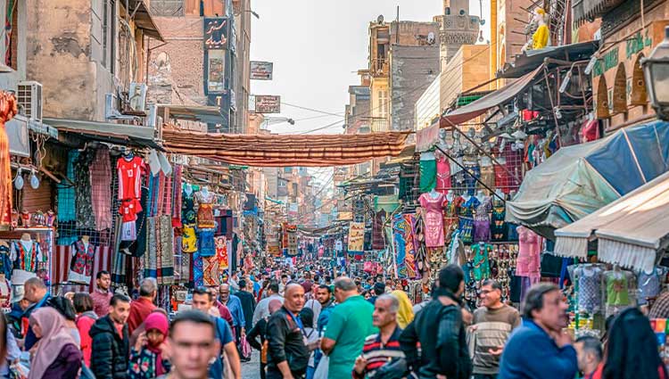 Personas paseando por una calle concurrida de El Cairo, la ciudad más poblada de África